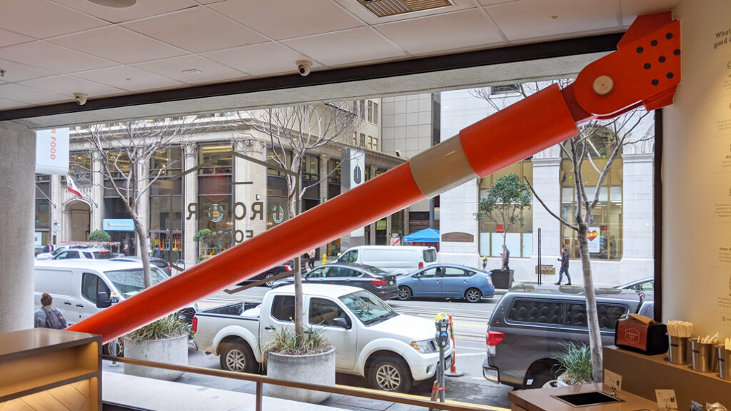 Interior view looking at Taylor damper through a shop window at 350 California St.